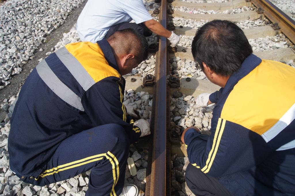 鐵路職工在仔細(xì)檢查鋼軌 鐵路職工在仔細(xì)檢查鋼軌