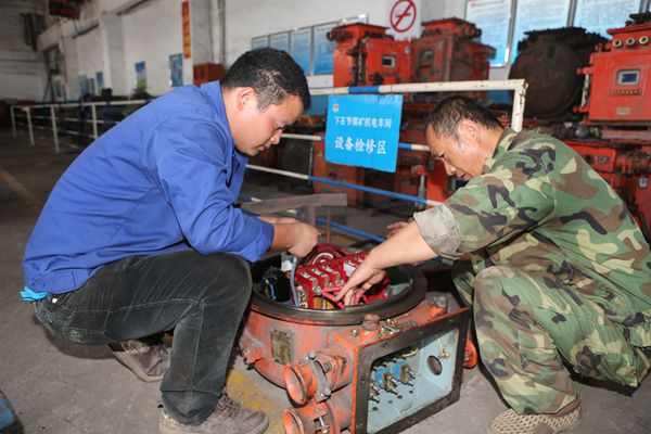 機電車間電修工徐庭軍和徒弟正在檢修開關