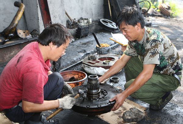 選運區(qū)維修班班長路續(xù)軒和工友對推土機變速箱部件進行整形